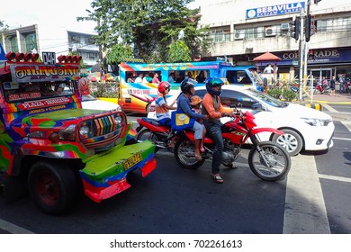 Cebu City, Philippines - January 15, 2015: Bikers wait at traffic light with cars and iconic jeepneys during Sinulog, a large festival each January.
