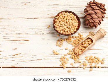 Cedar (Pine) nuts and cones on white wooden table. Selective focus. Top view, Copy space