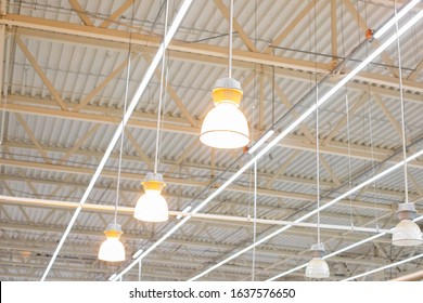 Ceiling With Bright Lamps In A Modern Warehouse. Image Of Bright Light, A Large Space For Trade, Storage, Commercial Activity.