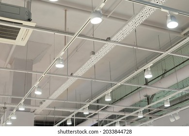 Ceiling With Bright Lights In A Modern Warehouse, Shopping Center Building, Office Or Other Commercial Real Estate Object. Directional LED Lights On Rails Under The Ceiling