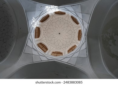 The ceiling of a building is covered in a pattern of squares and circles. The design is intricate and detailed, giving the impression of a dome. Scene is one of elegance and sophistication - Powered by Shutterstock