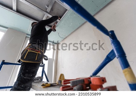 Ceiling installation with expert technicians In the room that is in the construction process.
