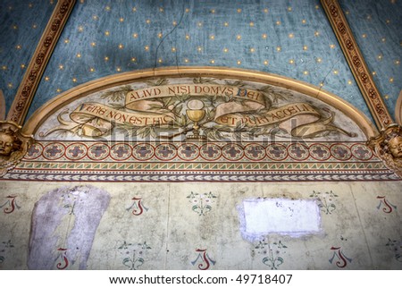 A ceiling with Latin word painted on it at an abandoned chateau.