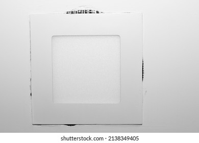 An in ceiling LED light panel has sheetrock not finished properly leaving some gaps around it. Holes in the ceiling sheetrock and paint around a square in ceiling LED light needs repairs to be flush.
