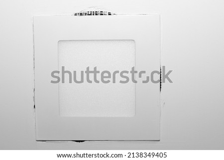 An in ceiling LED light panel has sheetrock not finished properly leaving some gaps around it. Holes in the ceiling sheetrock and paint around a square in ceiling LED light needs repairs to be flush.
