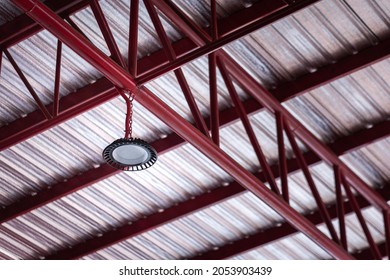 Ceiling LED lighting lamp on roof beam structure of warehouse yard in the factory. Indsutrial equipment object photo. Selective focus at the lamp part.