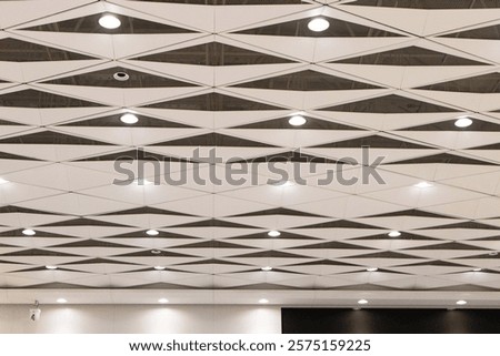 Ceiling with light bulbs lighting with ventilation pipes in airport station in China. Important component of house that enhances beauty. Most popular ceiling panels today. Modern architecture design.
