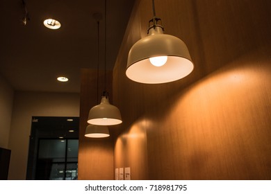 Ceiling Lighting Fixture Lamps Hanging Along The Curved Of Wooden Wall In Modern Cafe