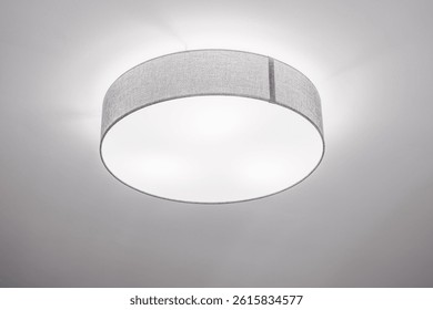 Ceiling llight with shallow drum shade with grey cotton diffuser in elegant minimalistic interior, selective focus