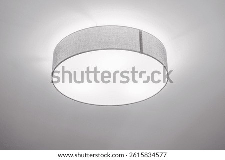 Ceiling llight with shallow drum shade with grey cotton diffuser in elegant minimalistic interior, selective focus