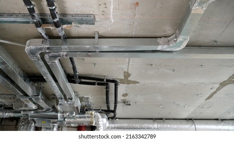 Ceiling In A New Apartment With A System Of Ventilation Pipes And Wires. Ventilation System In A Modern Residential Apartment During The Construction Phase, No People. 