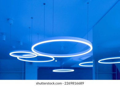 Ceiling with round modern LED lamps. Suspended fluorescent lights under the ceiling. Careful energy consumption, energy saving concept. Copy space