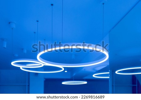 Ceiling with round modern LED lamps. Suspended fluorescent lights under the ceiling. Careful energy consumption, energy saving concept. Copy space