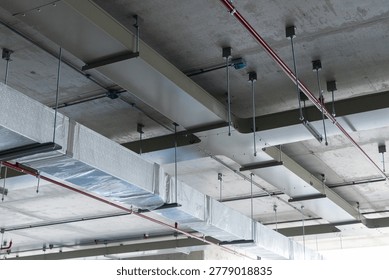 Ceiling view of HVAC ductwork installation wrapped in protective plastic, part of a modern air ventilation and climate control system.