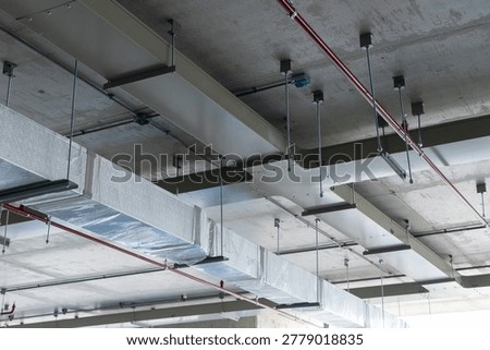 Ceiling view of HVAC ductwork installation wrapped in protective plastic, part of a modern air ventilation and climate control system.