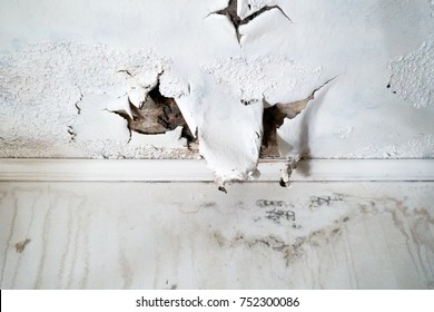 Ceiling and wall with rain damage due to violent weather and roof damage                               