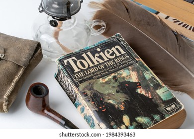 Celadna, Czechia - 06.01.2021: Vintage paperback edition of Tolkien's Lord Of The Rings. Smoking pipe, oil lamp, big feather still life