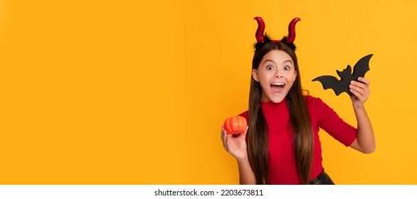 celebrate autumn party holiday. childhood fun. amazed evil child in imp horns hold bat. Halloween kid girl portrait, horizontal poster. Banner header with copy space. - Shutterstock ID 2203673811