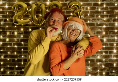 Celebrate event new year for couple of nice people - beautiful senior adult man and woman having party by night. Happiness lifestyle for mature retired people, party lights - Powered by Shutterstock