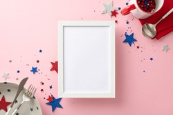 Celebrate Independence Day With Patriotic Table Arrangement. From Top View, See Plates, Cup, Cutlery, Festive Accessories On A Pastel Pink Background. Empty Photo Frame Perfect For Picture Or Message
