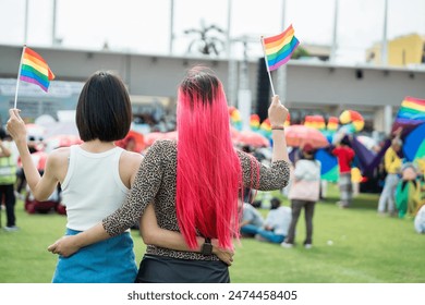 Celebrate in pride month festival. Pride movement transgender asian couple lesbian LGBT holding rainbow flag for freedom. Gatherings of friends in parade communities celebrating LGBTQ+ causes.