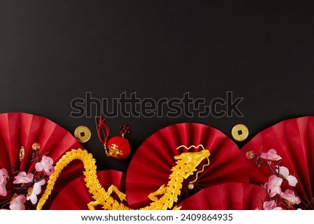 Celebrate the spirit of happy chinese New Year. Top view vertical photo of gold dragon, sakura, red folding fans, gold coins on black background with promo space