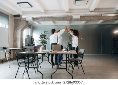 Celebrating, doing high five. Group of people are working in the office together as a team.