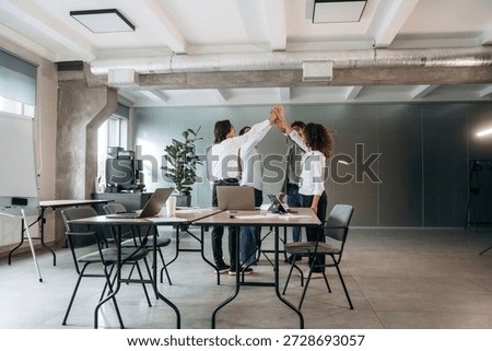 Celebrating, doing high five. Group of people are working in the office together as a team.