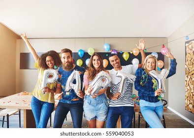 Celebrating friends holding PARTY balloons while raising their hands in celebration - Shutterstock ID 559040053