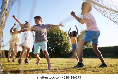 Celebrating goal at a multi generation family football game - Shutterstock ID 1184186293