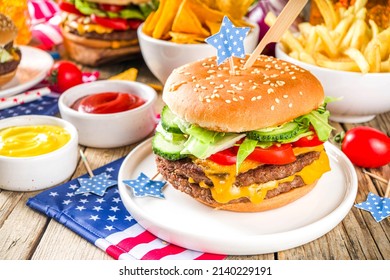 Celebrating Independence Day, July 4. Traditional American Memorial Day Patriotic Picnic With Burgers,  French Fries And Snacks, Summer USA Picnic And Bbq Concept, Old Wooden Background 