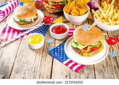 Celebrating Independence Day, July 4. Traditional American Memorial Day Patriotic Picnic With Burgers,  French Fries And Snacks, Summer USA Picnic And Bbq Concept, Old Wooden Background 