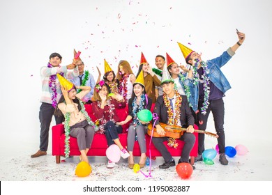 Celebrating New Year Together.Group Of Young Staff People In Hats Throwing Colorful Confetti And Looking Happy At Office.