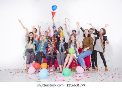 Celebrating New Year Together.Group Of Young Staff People In Hats Throwing Colorful Confetti And Looking Happy At Office.