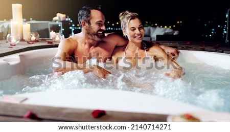 Celebrating our love the best way we know how. Shot of an affectionate mature couple relaxing in a hot tub together at night.