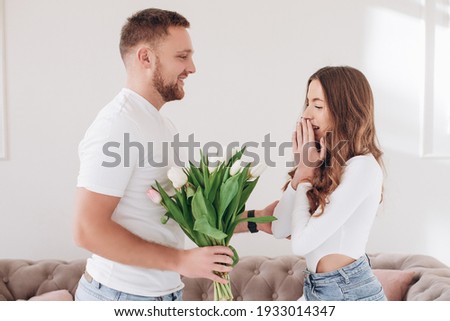 Celebrating Special Occasion. Giving girl a bouquet of colorful wilted tulips. Man greeting lady with international women's day. Couple separation, betrayed, misunderstood wife. 