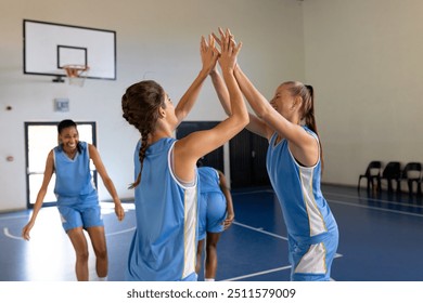 Celebrating victory in school gym, female basketball players high-fiving teammates. Celebration, sports, team spirit, high five, athletes - Powered by Shutterstock