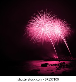 Celebration with colorful fireworks over the sea near a marina