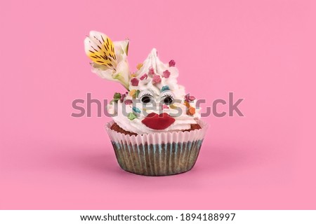 celebration cupcake with funny face on a pink background