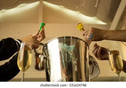 Celebration Hands Pulling A Christmas And New Year Pop Up Cracker With Champagne Glasses