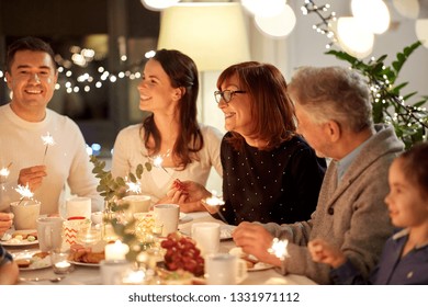 celebration, holidays and people concept - happy family with sparklers having tea party at home - Powered by Shutterstock