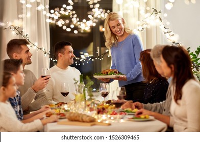 Celebration, Holidays And People Concept - Happy Woman Offering Roast Chicken To Family Having Dinner Party At Home