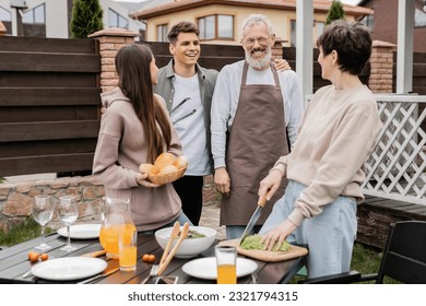 celebration of parents day concept, family photo, excited and happy siblings near middle aged mom and dad, grill party, standing on backyard of summer house, bbq preparations - Powered by Shutterstock