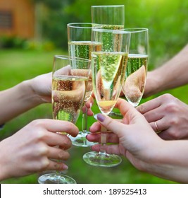 Celebration. People Holding Glasses Of Champagne Making A Toast Outdoors