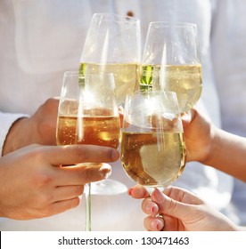 Celebration. People Holding Glasses Of White Wine Making A Toast