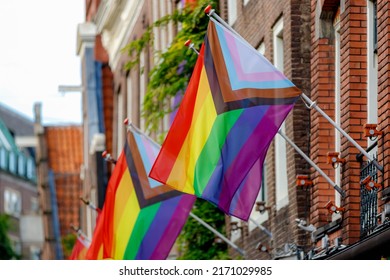Celebration of pride month in Amsterdam, New rainbow flag hanging outside the building, Symbol of Gay, Lesbian, Bisexual and Transgender, LGBT community in Holland, Social movements, Netherlands.