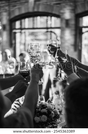 Celebration, toasting, wine glasses, cheers, black and white, party, gathering, friends, family, wedding, banquet, event, joyful, hands, clinking glasses, drink, social gathering,