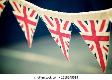 Celebratory Vintage British Union Jack Flag Bunting Hanging Outdoors In Preparation For A Street Party