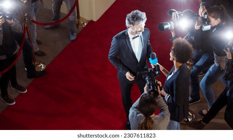 Celebrity being interviewed photographed by paparazzi photographers at red carpet event - Shutterstock ID 2307611823