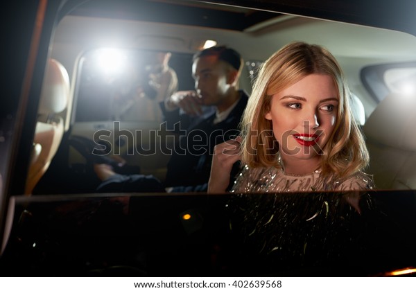 Celebrity couple in back of a car, photographed\
by paparazzi